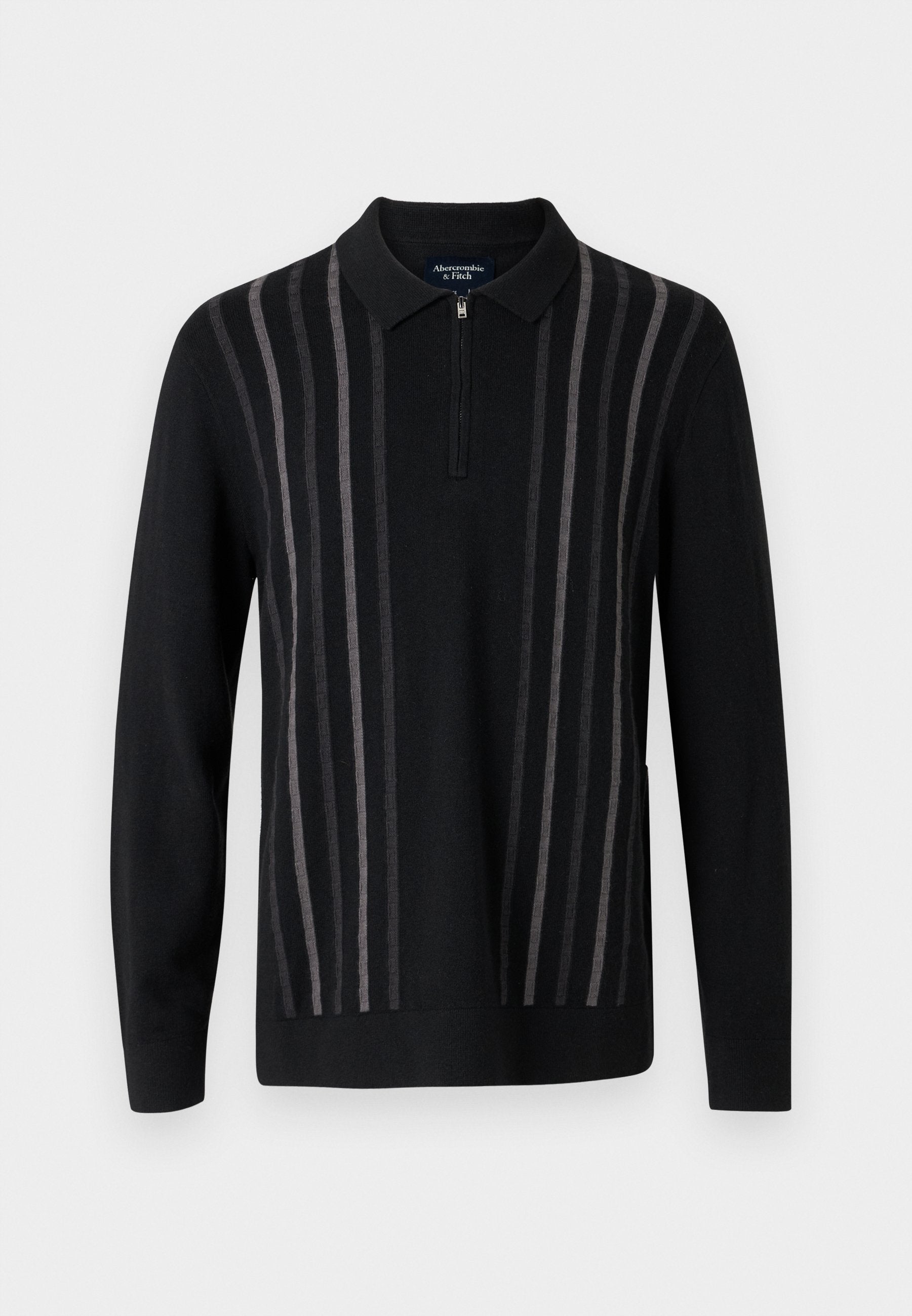 Schwarzer Pullover mit Reißverschlusskragen, mit vertikalen grauen Streifen, aus weichem Strickstoff, mit langen Ärmeln und seitlichen Schlitzen.