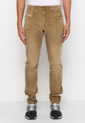 Beige Cord-Hosen mit schmalem Schnitt, Fronttaschen und einem kleinen Logostick. Weiches Material mit subtiler Rippstruktur, kombiniert mit schwarzen Sportschuhen.