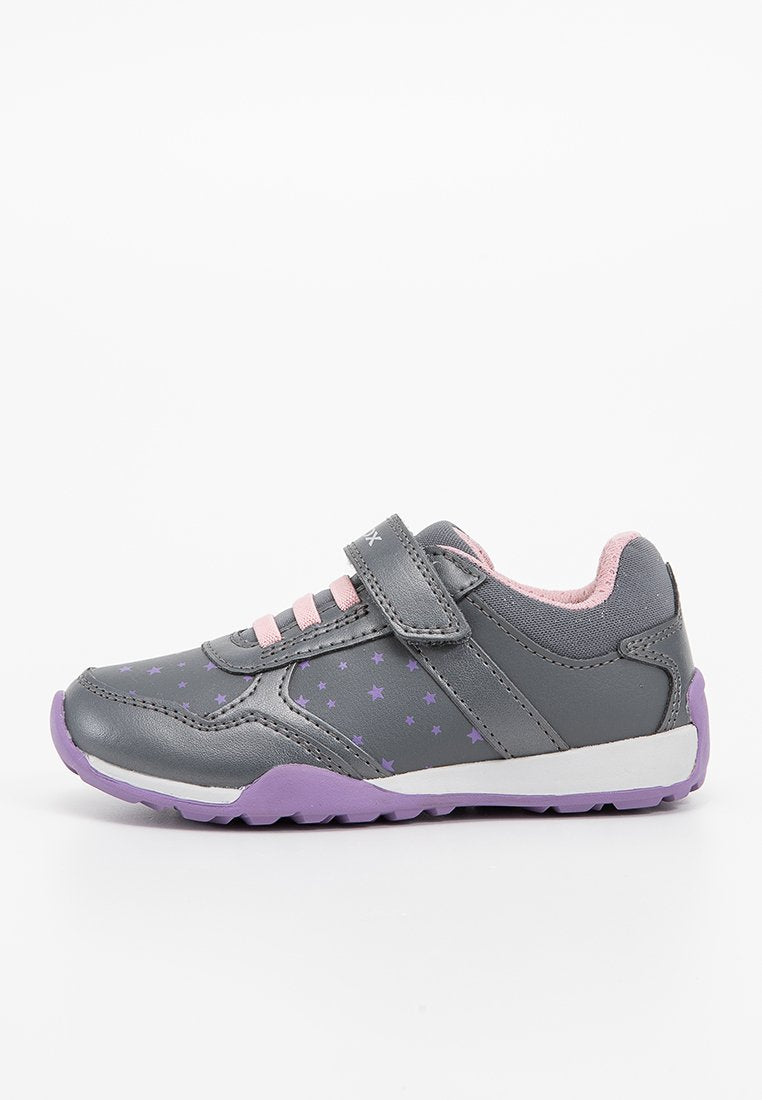 Graue Sneaker mit lila Akzenten und Sternmustern, ausgestattet mit rosa Schnürsenkeln und einem Klettverschluss, hergestellt aus synthetischem Material mit einer strukturierten Laufsohle.