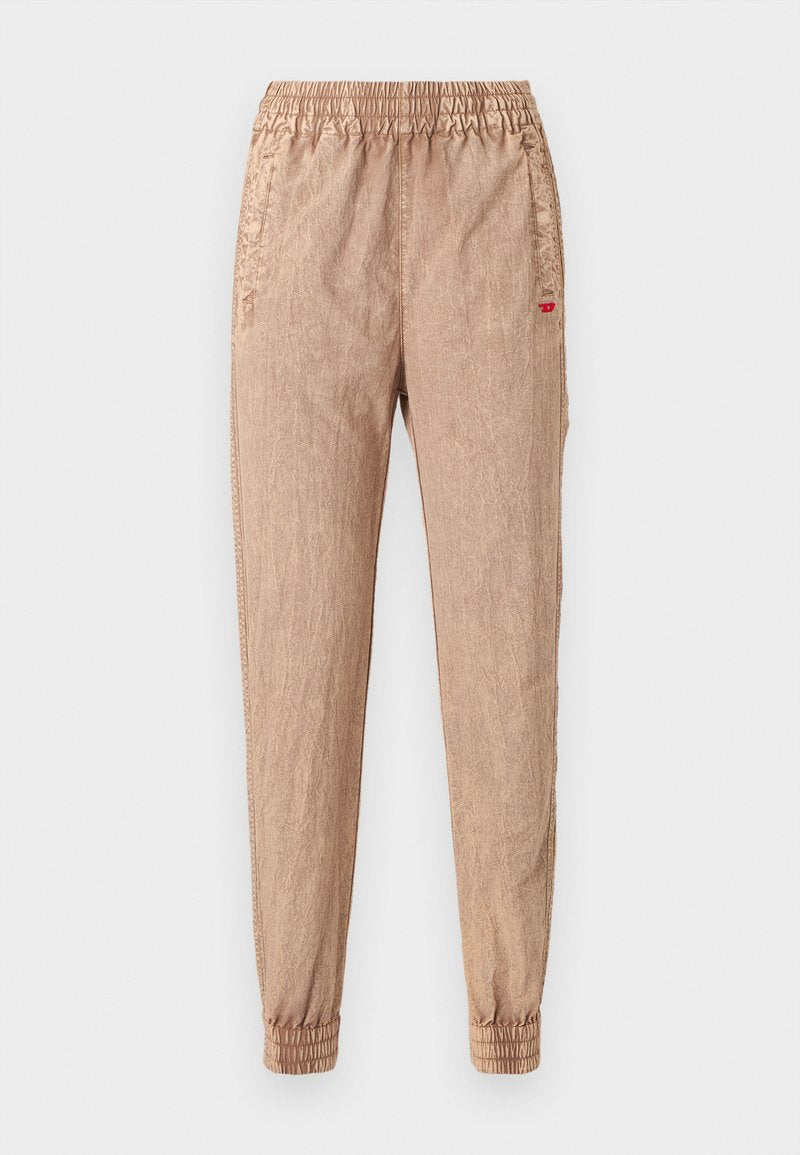 Beige Jogginghosen mit elastischem Bund und gekräuselter Textur, ausgestattet mit gerippten Bündchen und Seitentaschen. Enthält ein kleines rotes Logodetail.