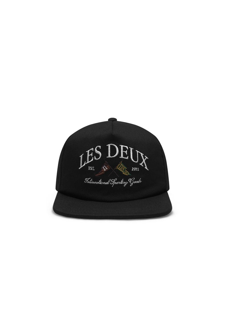 Schwarze Kappe mit gesticktem Text "LES DEUX" und "Est. 2011" in Weiß, mit dekorativen Elementen. Starre Krempe und verstellbarer Riemen auf der Rückseite.