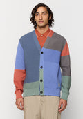 Strickjacke mit Patchwork-Design in Blau, Grau, Grün und Orange. Verfügt über einen tiefen V-Ausschnitt, sechs große Knöpfe und einen strukturierten Stoff.