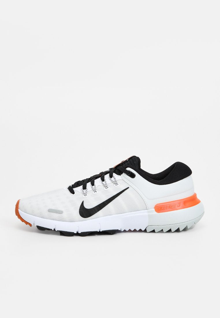Nike Sport Schuhe in Weiß, Schwarz und Orange. Verfügen über ein strukturiertes Mesh-Obermaterial, schwarze Schnürsenkel und eine Gummisohle mit Profilmustern.