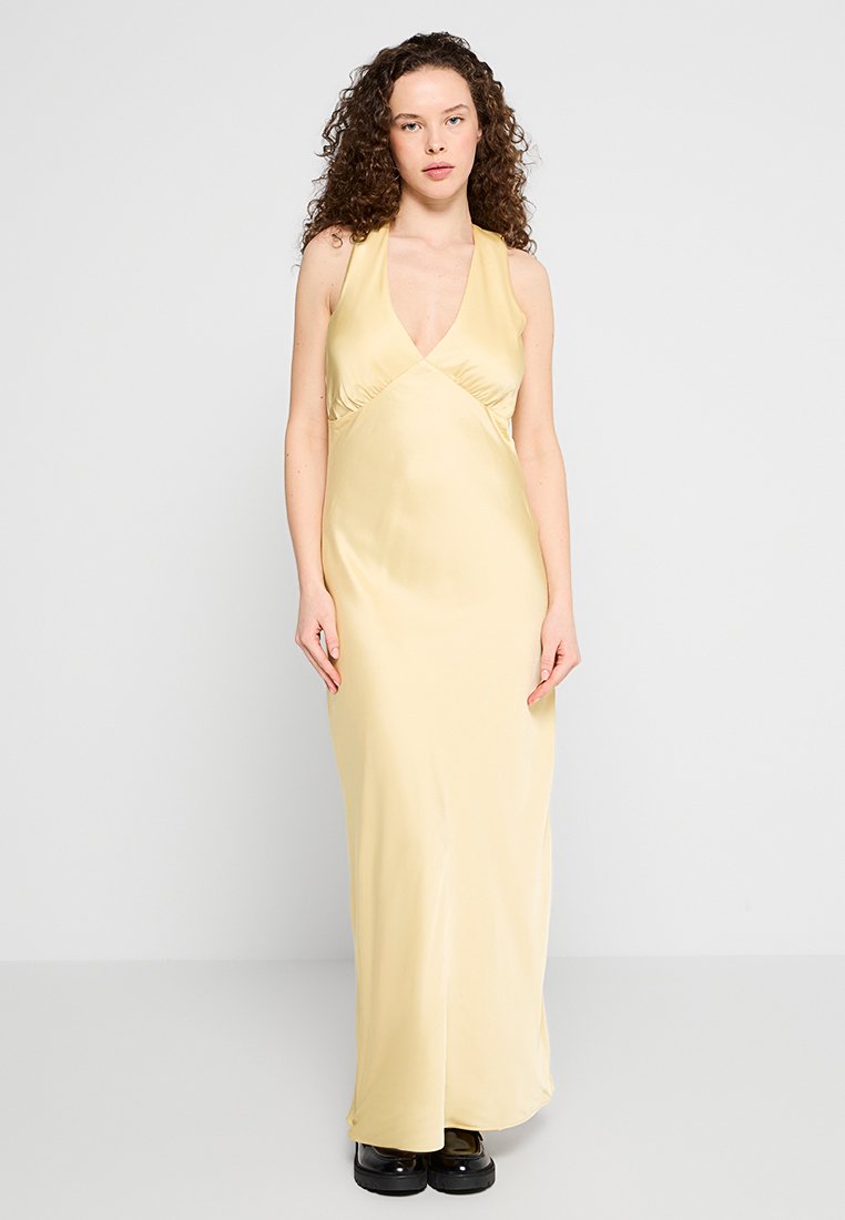 Langes, neckholder Kleid aus weichem, gelbem Satin mit enganliegendem Oberteil und fließendem Rock; glatte Textur, minimales Design und knöchellang.