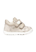 Hellbeige Kleinkind-Sneaker mit zwei Klettverschlüssen, geprägten Stern- und Schmetterlingsmustern und einer weißen flexiblen Sohle.