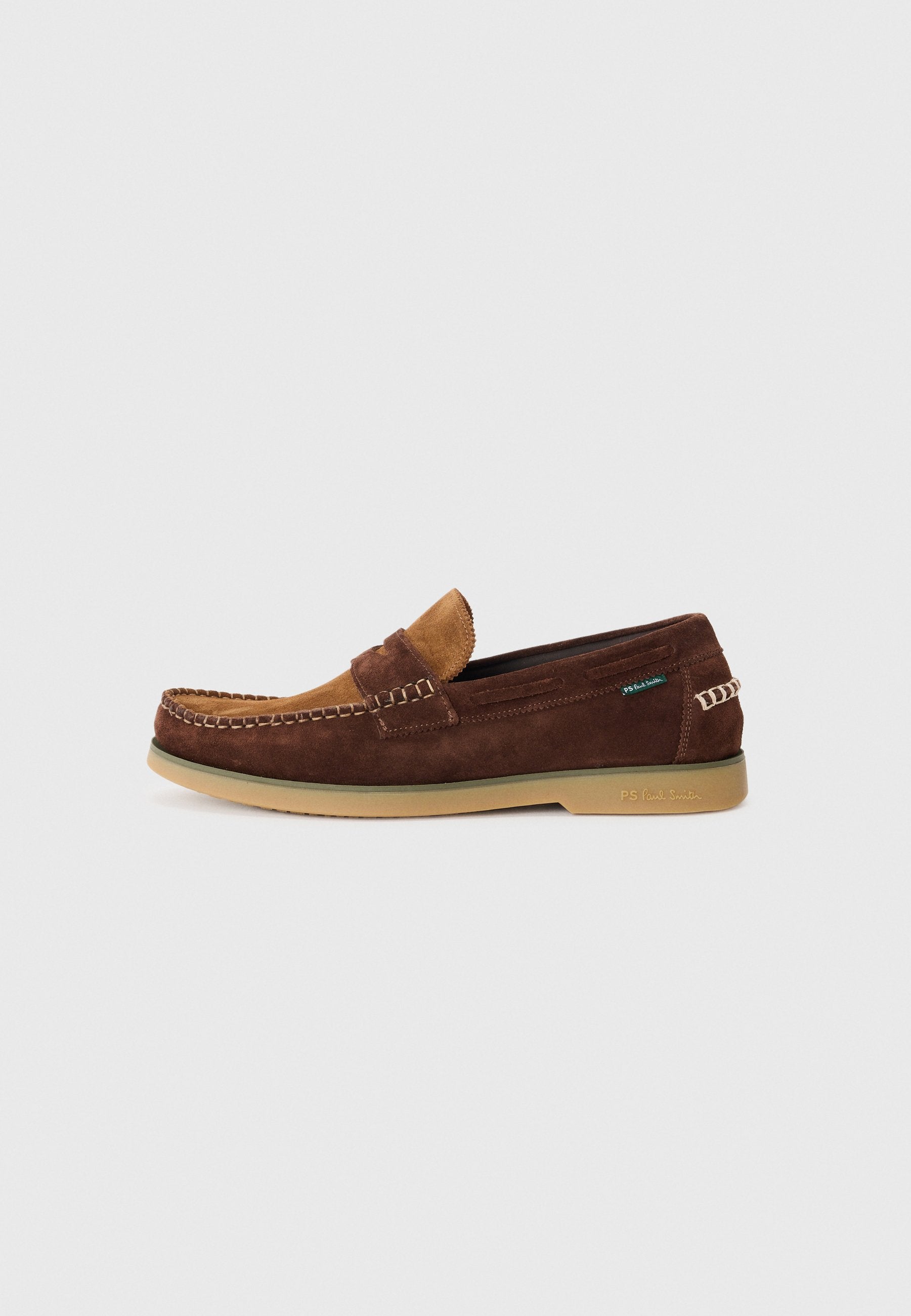 Braune Wildleder-Loafer mit einem Akzent aus hellbraunem Leder, Gummisohle und dekorativer Stickerei. Verfügt über ein Slip-On-Design und eine geprägte Markenkennung an der Seite.