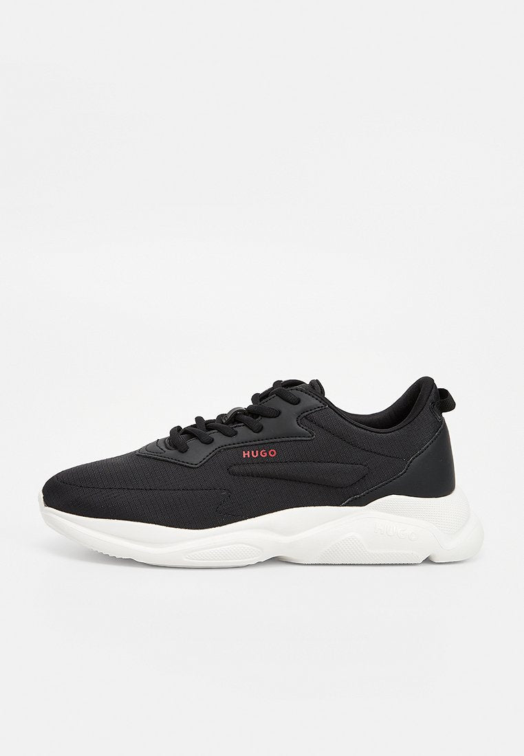 Schwarzer Sneaker mit weißer Sohle, Schnürdesign, rotem "HUGO"-Logo an der Seite und Obermaterial aus strukturiertem Stoff.