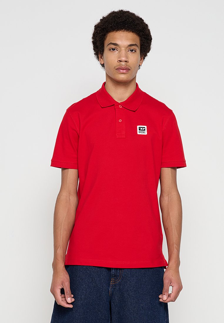 Rotes Baumwoll-Poloshirt mit Kragen, kurzen Ärmeln und einem kleinen Markenlogo auf der Brust. Glatte Textur und taillierte Passform.