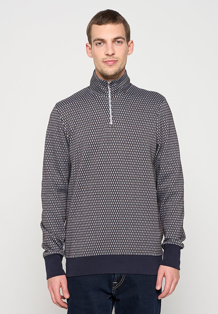 Marineblauer Pullover mit hohem Kragen und halbseitigem Reißverschluss. Mit strukturiertem Diamantmuster sowie gerippten Bündchen und Saum versehen.