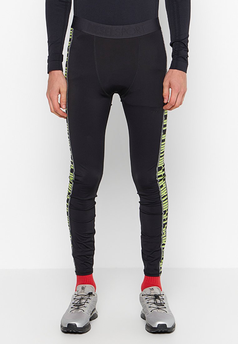 Schwarze Sportleggings mit enganliegendem Schnitt, ausgestattet mit einem neongrünen, gemusterten Streifen an den Seiten und einem elastischen Bund.