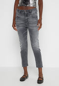 Graue Denim-Jeans mit schmaler Passform, ausgestattet mit leichter Used-Optik, fünf Taschen und Knopfverschluss. Kombiniert mit schwarzen, nietenbesetzten Ballerinas.