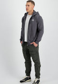 Grauer Reißverschluss-Hoodie mit Taschen, getragen über einem weißen T-Shirt, kombiniert mit grünen Cargo-Hosen und schwarzen Sneakers. Lässig, entspannte Passform.