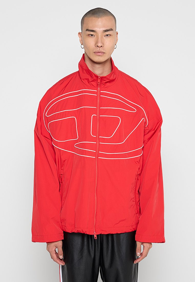 Rote Daunenjacke mit hohem Kragen, die ein weißes abstraktes Logodesign auf der Vorderseite aufweist. Das Material scheint leicht und strukturiert zu sein.