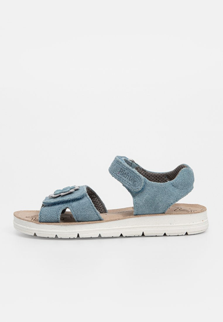 Blaue Wildleder-Sandalen mit offenem Zehenbereich, verstellbaren Knöchel- und Vorderriemen, gepolsteter Sohle und dekorativem Blumendetail am Vorderriemen.