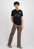 Schwarzes Baumwoll-T-Shirt mit einem NASA-Logo auf der Brust, kombiniert mit hellbraunen Cargo-Hosen mit großen Seitentaschen und einer lockeren Passform.