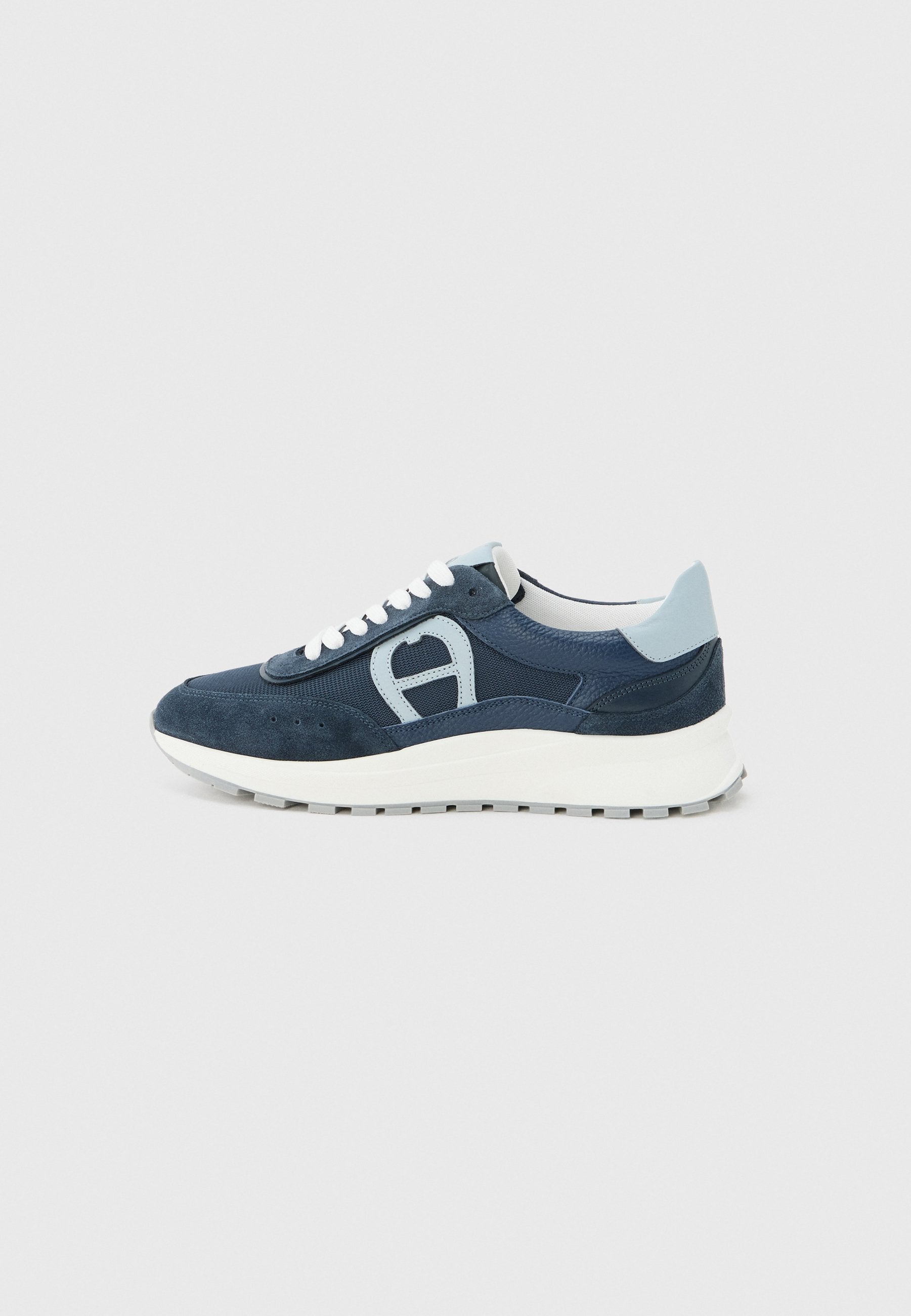 Marineblaue und hellblaue Sneaker mit weißer dicker Sohle und Schnürsenkeln, seitlichem Logodetail und gepolstertem Fersenkragen.