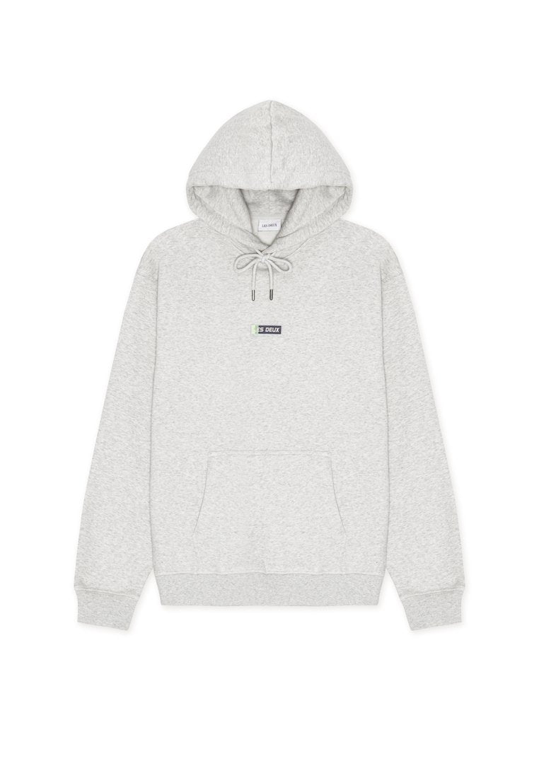 Hellgrauer Hoodie aus weichem Stoff, mit einer Fronttasche, Kordelzug und einem kleinen Logo-Patch auf der Brust. Gerippte Bündchen und Saum.
