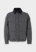 Graue Steppjacke mit gestepptem Design, Cordkragen, Druckknöpfen, Seitentaschen und gerippten Bündchen, aus einem glatten, strukturierten Material.