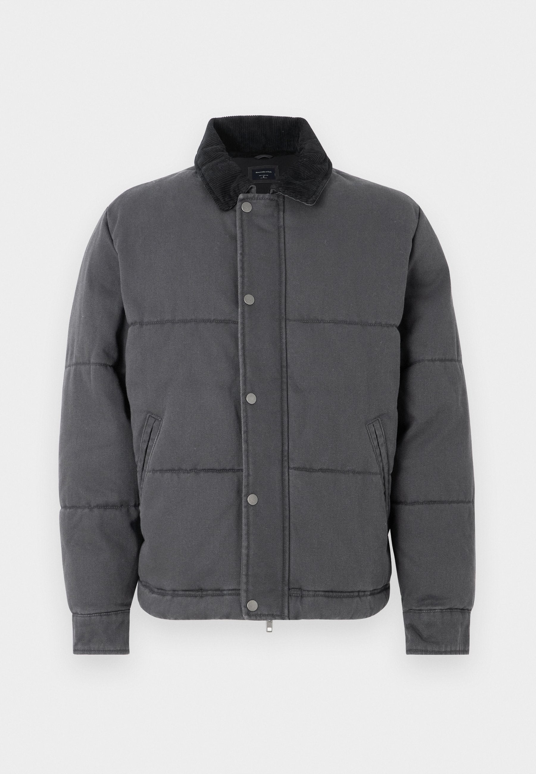Graue Steppjacke mit gestepptem Design, Cordkragen, Druckknöpfen, Seitentaschen und gerippten Bündchen, aus einem glatten, strukturierten Material.