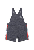 Navyblaue kurze Latzhosen aus strukturiertem Stoff, mit verstellbaren Trägern, zwei Fronttaschen und roten und weißen Seitenakzenten.