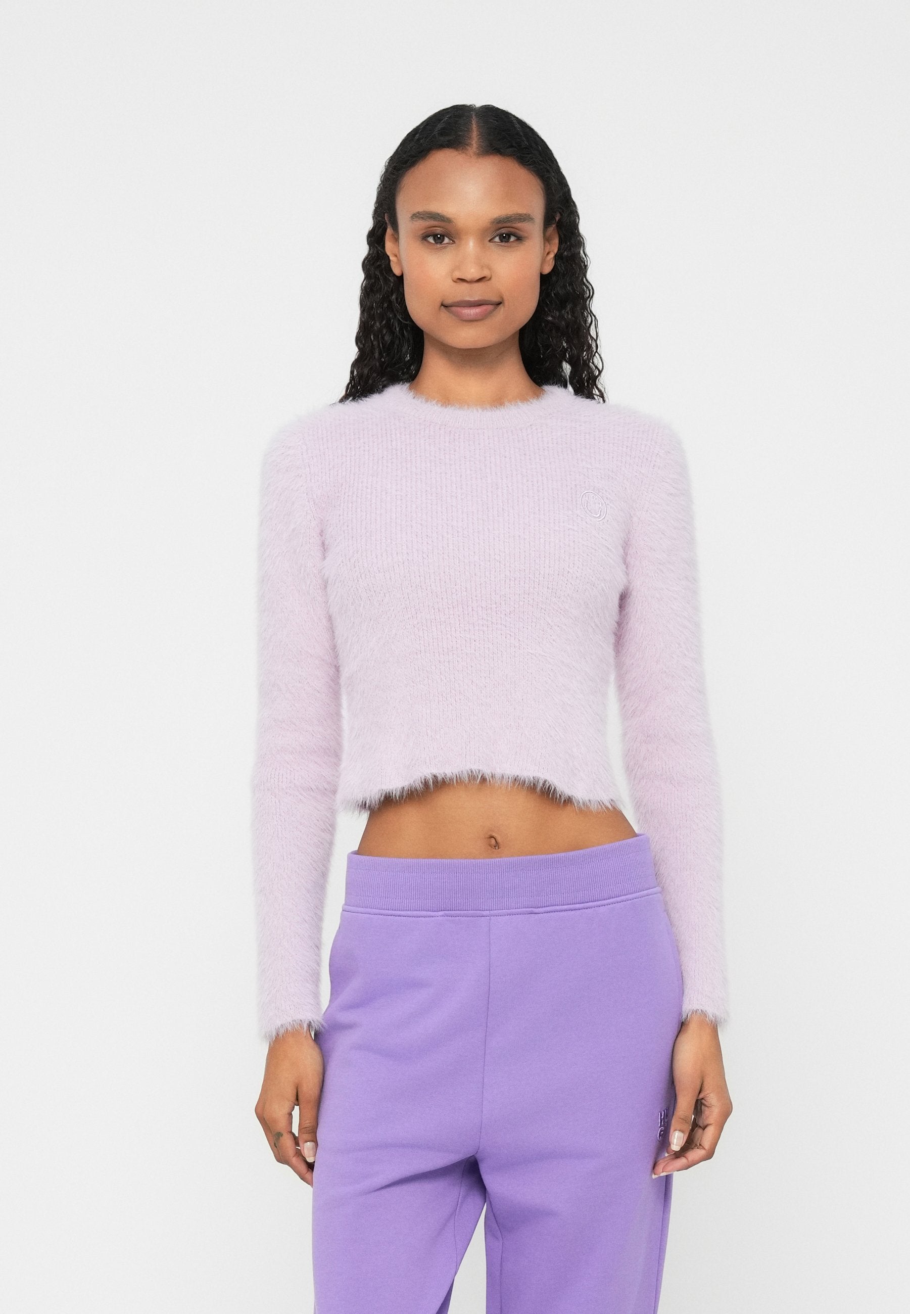 Hellvioletter, kurz geschnittener Pullover aus flauschigem Material mit langen Ärmeln und einer dezent gestrickten Textur am Halsausschnitt.