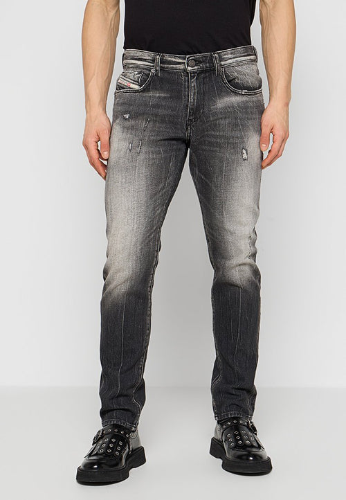 Schmal geschnittene schwarze Jeans mit ausgewaschenen und abgenutzten Details, aus Denim gefertigt, mit fünf Taschen und einem Reißverschluss.