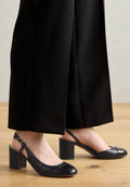 Schwarze Slingback-High Heels mit runder Spitze, ausgestattet mit einem glänzenden, patinierten Akzent an der Spitze, einem blockförmigen Absatz und einem Schnallenriemen.