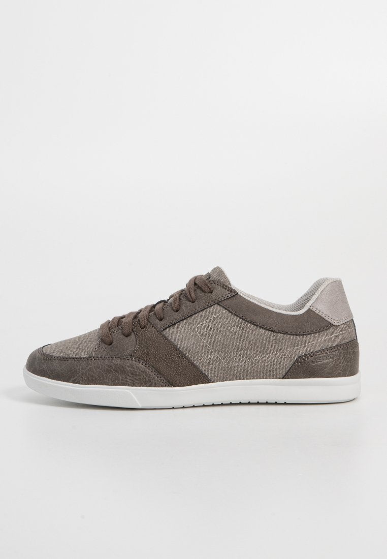 Sneaker aus einer Mischung aus hellbraunem und dunkelbraunem Stoff, Lederakzenten, weißer Gummisohle, runder Zehenpartie und flachem Schnürsystem.