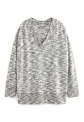 Grau-weiß meliertes Sweatshirt mit V-Ausschnitt, überschnittenen Schultern und gerippten Bündchen sowie Saum. Weicher Stoff mit entspannter Passform.