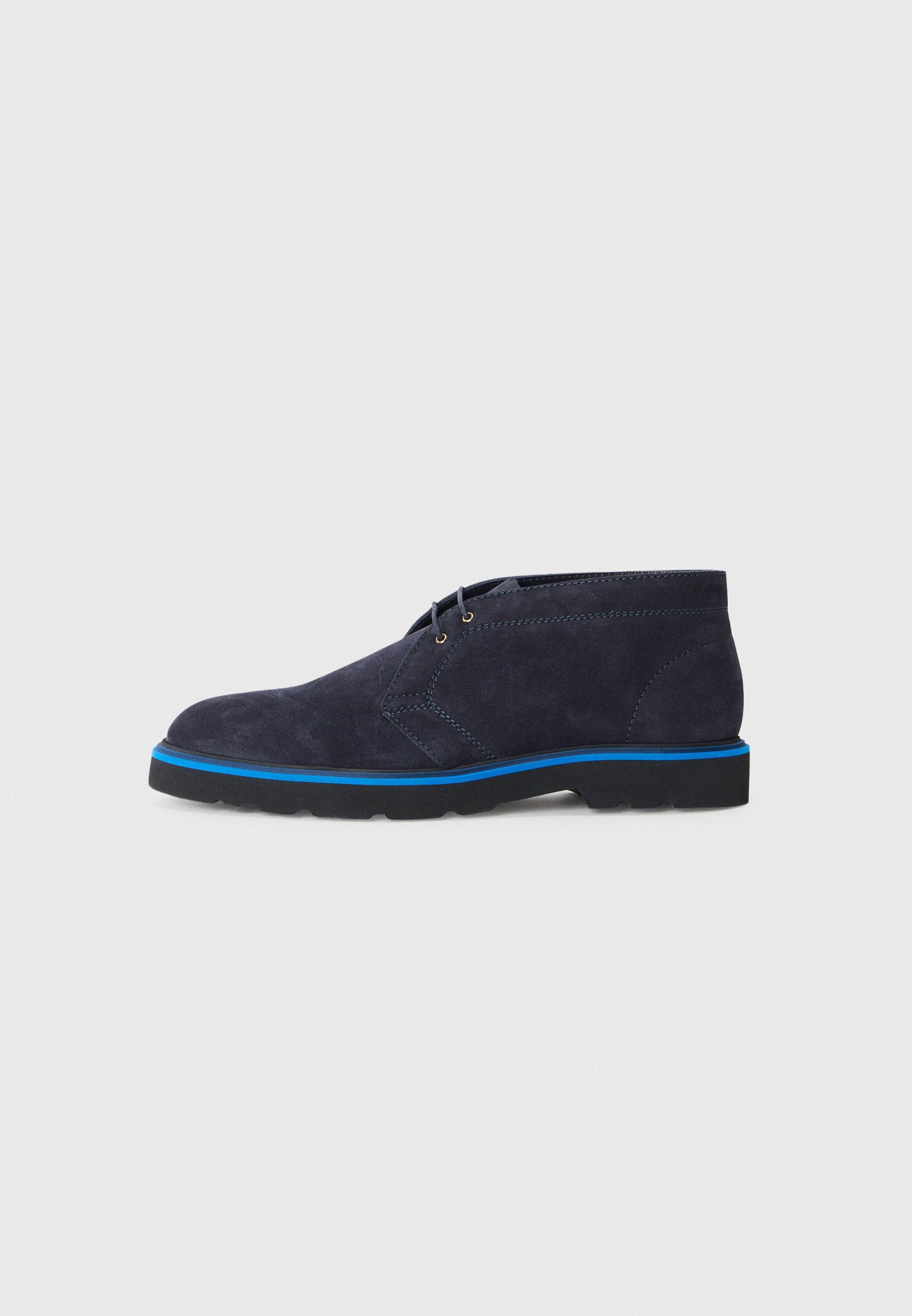 Marineblaue Wildleder-Stiefeletten mit runder Zehenpartie, kontrastierender blauer Außensohle und minimalistischem Schnürdesign; die Textur wirkt weich und edel.