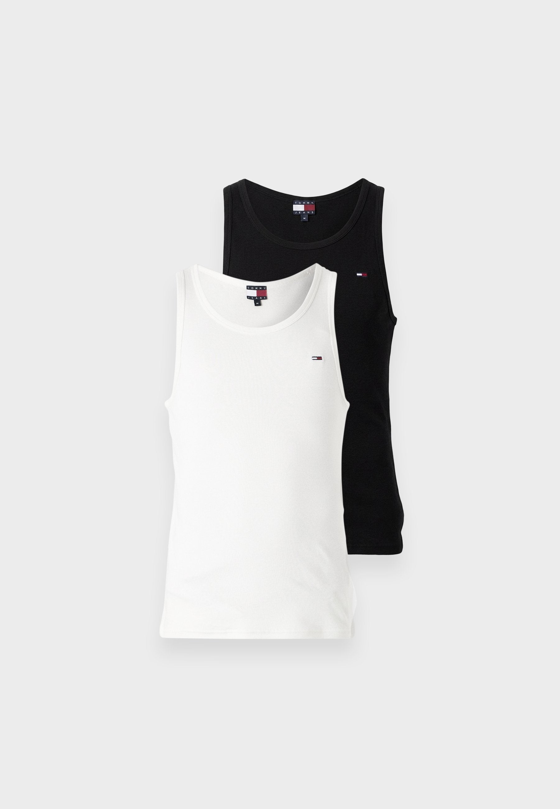 Zwei ärmellose Tanktops mit Rundhalsausschnitt, eines weiß und eines schwarz, jeweils mit einem kleinen rot-weiß-blauen rechteckigen Logo auf der Brust.