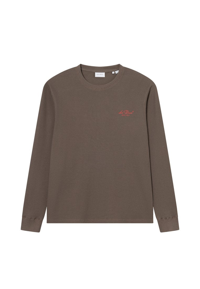 Braunes Langarm-T-Shirt aus strukturiertem Stoff, mit einem roten Logo auf der Brust, Rundhalsausschnitt und enganliegenden Ärmelbündchen.