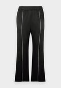 Schwarze Sporthose mit tailliertem Bund, weißen Seitenstreifen und ausgestelltem Bein. Hergestellt aus weichem, dehnbarem Stoff.