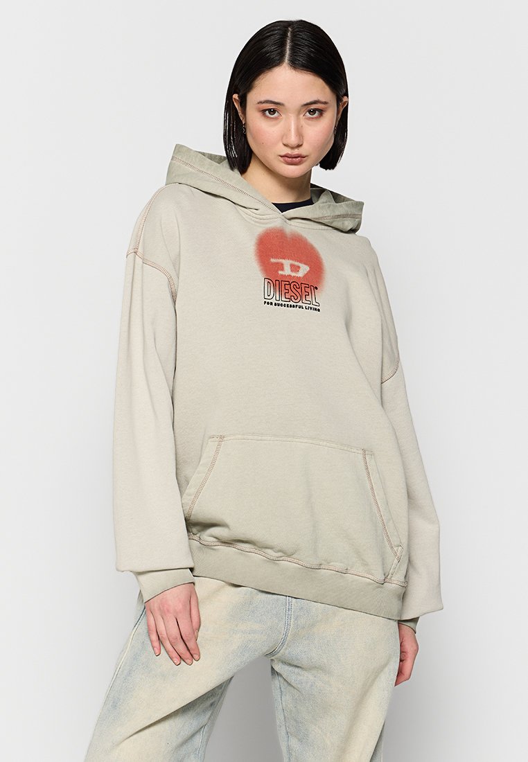 Beige Kapuzenpullover mit einer großen Fronttasche, gerippten Bündchen und einer weichen Textur. Auf der Brust befindet sich ein rotes, rundes Grafikdesign mit dem "DIESEL"-Logo.
