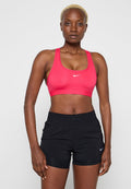 Rosa Sport-BH mit rundem Ausschnitt und Logo, kombiniert mit schwarzen Sportshorts mit elastischem Bund und Logo.