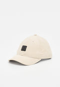 Beige Kordhut mit gebogenem Schirm und schwarzem rechteckigem Patch, auf dem zwei vertikale weiße Linien mittig auf der Vorderseite angeordnet sind.