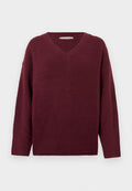 Weinroter V-Ausschnitt-Pullover aus weichem, strukturiertem Material mit weiten Ärmeln und geripptem Saum. Einfaches, klassisches Design ohne Verzierungen.