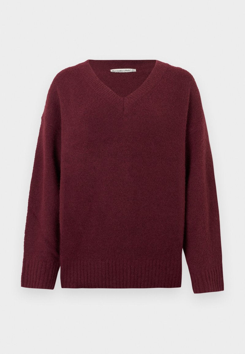 Weinroter V-Ausschnitt-Pullover aus weichem, strukturiertem Material mit weiten Ärmeln und geripptem Saum. Einfaches, klassisches Design ohne Verzierungen.