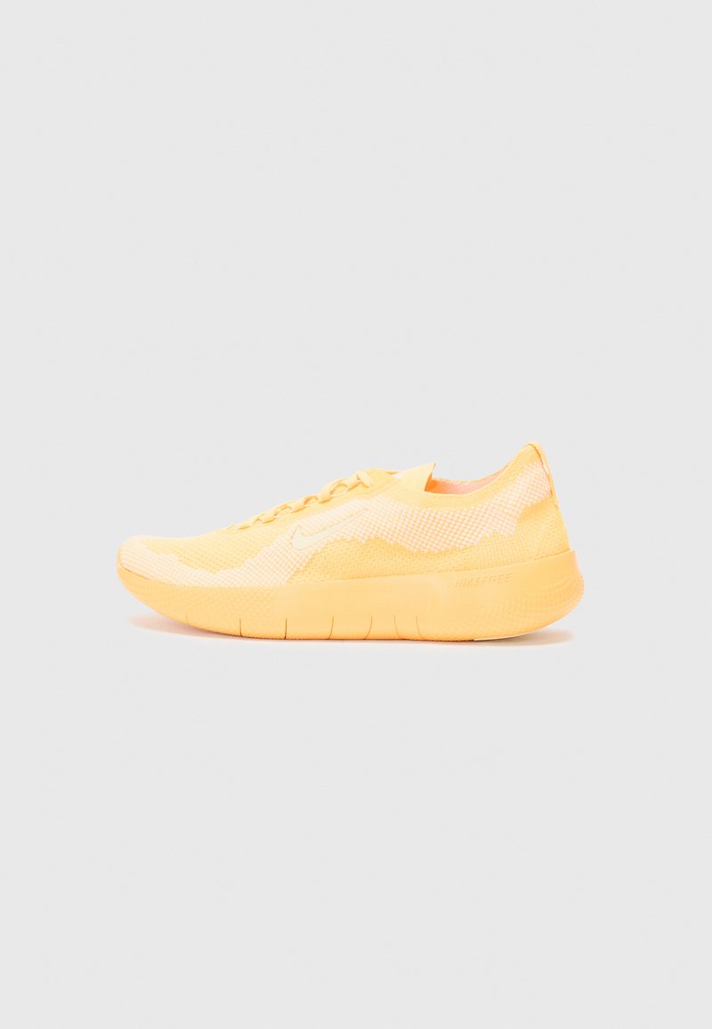 Sportliche Schuhe mit einem gelben Mesh-Obermaterial und strukturierten Details, ausgestattet mit einem abgerundeten Zehenbereich, Schnürverschluss und einer flexiblen Gummisohle.