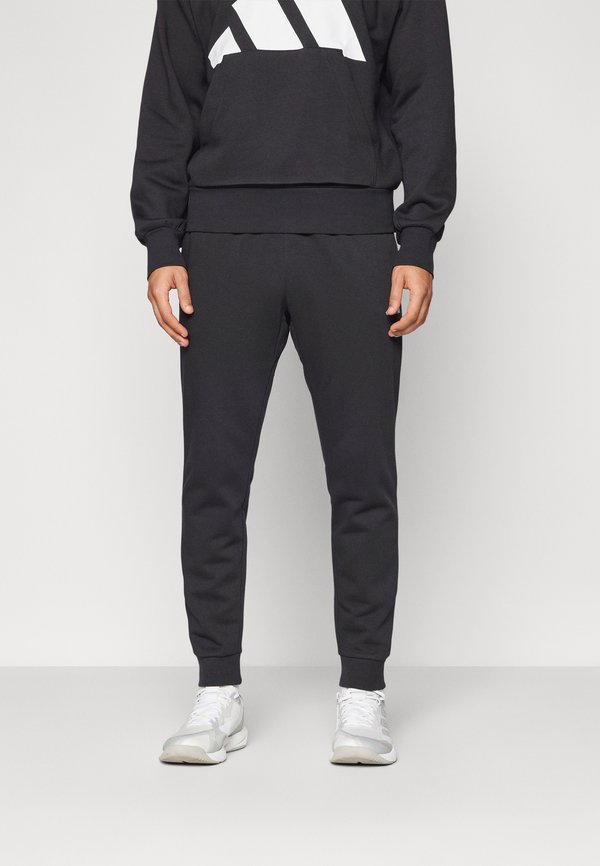 adidas Sportswear ESSENTIALS FEELCOZY FLEECE - Tracksuit bottoms - black/white
