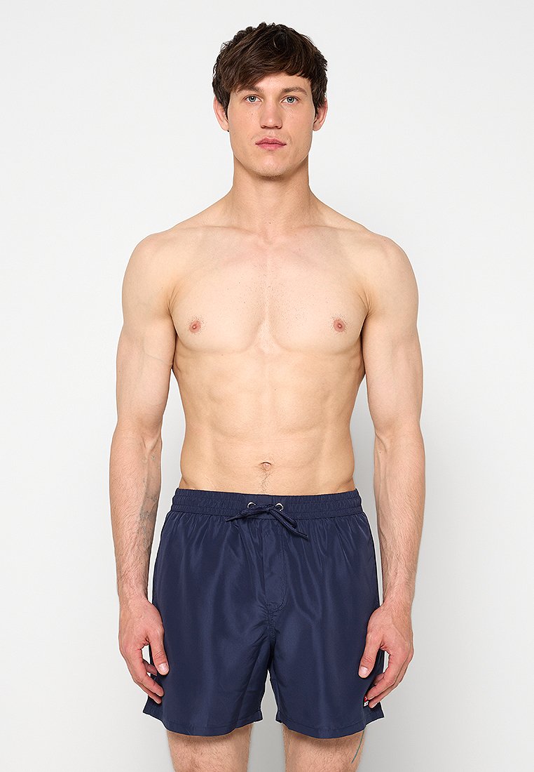 Marineblaue Badeshorts mit elastischem Bund, Kordelzug und glatter Textur. Knielang mit einfachem Design.