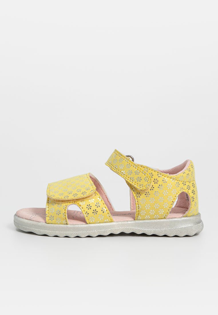 Gelbe Sandalen mit floralen Ausschnitten, Klettverschluss und einer silbernen strukturierten Sohle. Das Innere ist pink und verfügt über eine gepolsterte Fußbett.