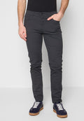 Graue Baumwollhose mit schmaler Passform, ausgestattet mit vorderen Taschen und einer glatten Textur. Kombiniert mit marineblauen Sneakers mit weißen Schnürsenkeln.