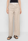 Beige weite Hosen mit einem Kordelzugbund und einer leichten Textur. Kombiniert mit dunklen Sandalen. Sichtbares Modell von der Taille abwärts.