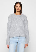 Grauer Strickpullover mit rundem Ausschnitt, überschnittenen Schultern und langen Ärmeln. Der Stoff hat eine weiche, strukturierte Oberfläche.