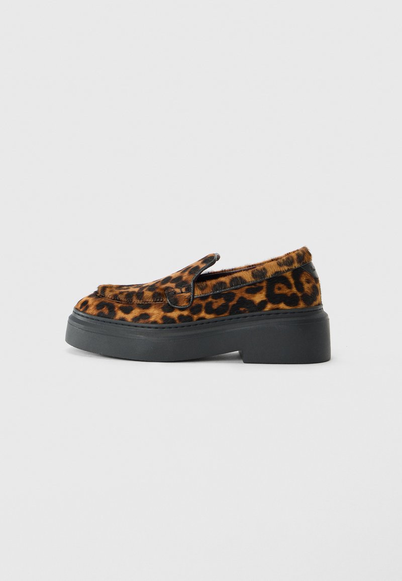 Loafer-Schuh mit Obermaterial in braunem und schwarzem Leopardenmuster und dicker schwarzer Plateausohle auf weißem Hintergrund.