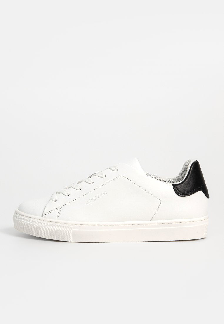 Weiße Leder-Sneaker mit einem schwarzen Akzent an der Ferse. Mit abgerundetem Zehenbereich, flacher weißer Sohle und einfarbigen Schnürsenkeln. Minimale Markenkennzeichnung vorhanden.