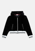 Schwarze Samt-Cropped-Jacke mit Kapuze, ausgestattet mit einem silbernen Reißverschluss, zwei Seitentaschen und weißen gerippten Bündchen sowie Saum.