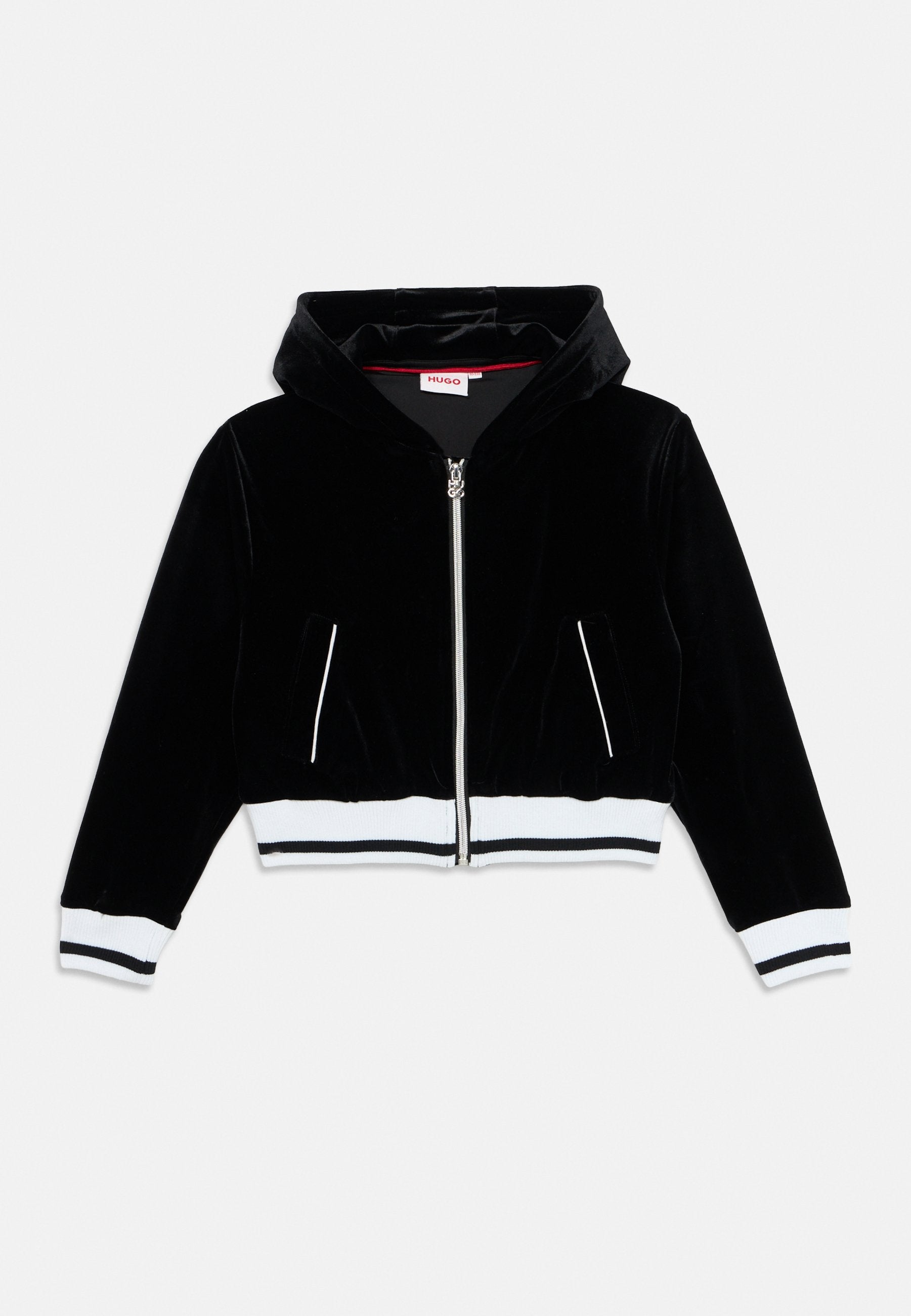 Schwarze Samt-Cropped-Jacke mit Kapuze, ausgestattet mit einem silbernen Reißverschluss, zwei Seitentaschen und weißen gerippten Bündchen sowie Saum.