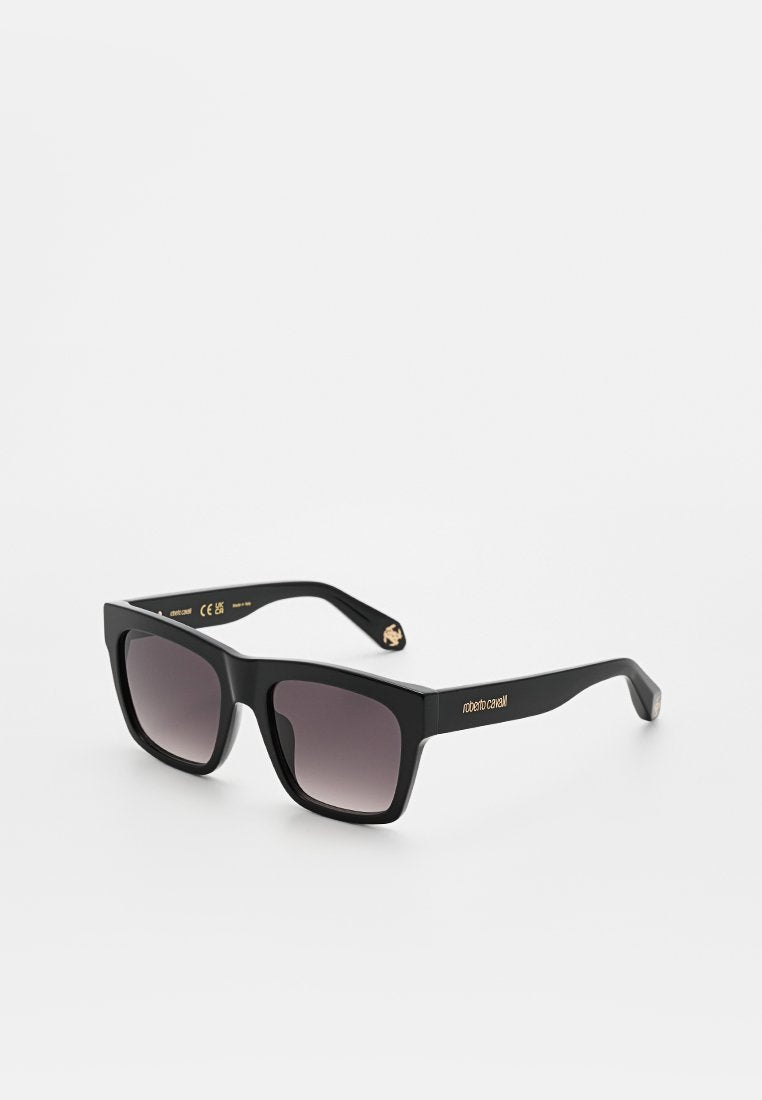 Schwarze Sonnenbrille mit quadratischem Rahmen, verlaufenden dunklen Gläsern und dem goldenen Logo "roberto cavalli" am Bügel, abgebildet vor weißem Hintergrund.